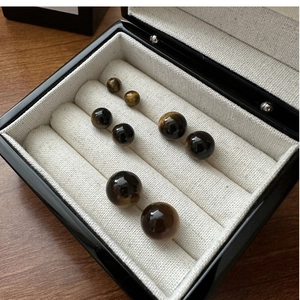 Detail of four pairs of tiger eye stud earrings in various sizes with cat-eye effect