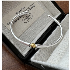 Détail d'un bracelet ouvert en argent S925 avec perle dorée dans son écrin à bijoux