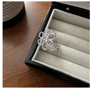 Detailed macro view of S925 silver hollow flower ring with a sparkling zircon center