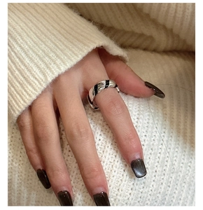 Close-up of S925 sterling silver twist ring with black enamel glaze on model finger