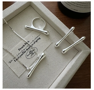 Detailed close-up of a minimalist S925 sterling silver jewelry set in a luxury display