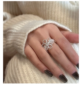 Macro detail of S925 sterling silver flower ring with zircon on model finger