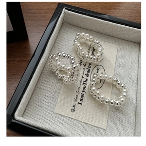 Macro view of three-piece S925 silver beaded rings with white pearls on a linen tray