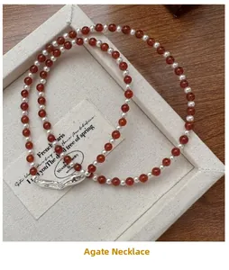 Detail of red agate beads and silver spacers on jewelry tray with a wooden background