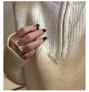 Detail shot of a minimalist S925 silver T-bar jewelry set with necklace and ring