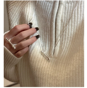 Close-up of S925 sterling silver liquid-style necklace and ring set on knit sweater