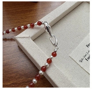 Detail of S925 silver necklace with red agate beads and small white pearls