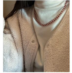 Close-up of S925 silver necklace with red agate and white pearls on a model neck