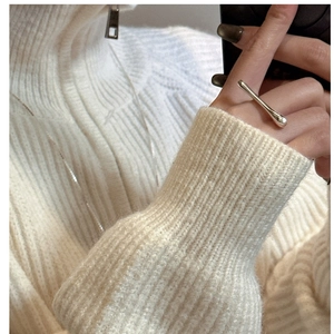 Detail of minimalist S925 silver liquid style ring worn on a white knitted sweater