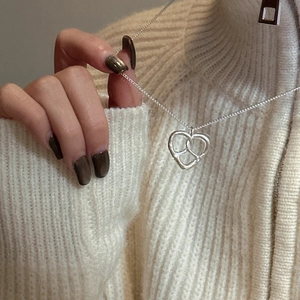Collier cœur évidé en argent S925 minimaliste porté sur un pull en maille douillet