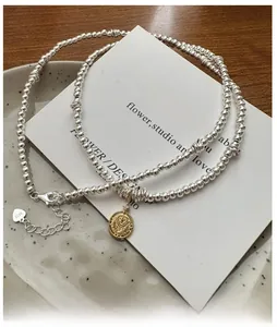 Detail of S925 sterling silver beaded necklace with golden coin pendant and clasp