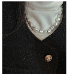 Baroque irregular pearl necklace worn with a tweed jacket for a minimalist elegant style