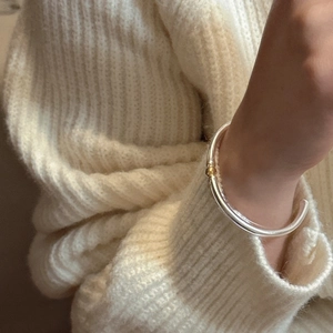 Bracelet jonc ouvert en argent sterling S925 avec perle dorée porté sur le poignet