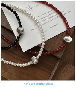 Macro shot of S925 silver beaded necklaces with cat-eye stones and brushed metal beads