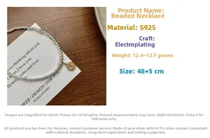 Detail view of S925 sterling silver beaded necklace with vintage gold coin pendant