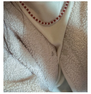 Detail view of S925 sterling silver necklace with red agate and white pearls on a model