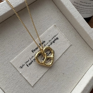 Collier minimaliste en argent S925 avec pendentif nœud en cœur finition dorée