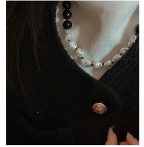 Detail of s925 silver necklace with black agate beads and baroque pearls on model