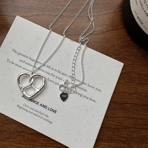 Collier en argent sterling S925 avec pendentif nœud en cœur sur carte texturée