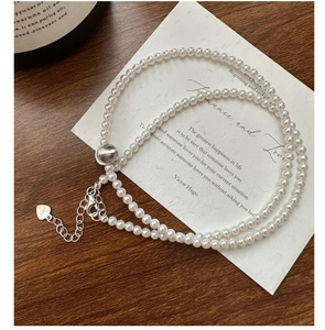 Close-up of double-layer S925 silver pearl necklace with a heart tag on a card