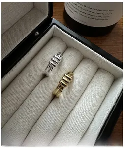 Detailed view of silver and gold twisted rope rings displayed in a luxury jewelry box