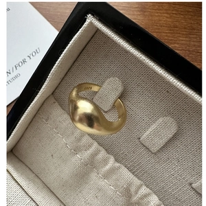 Macro shot of S925 silver wave ring with matte golden finish in a jewelry box