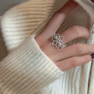 S925 sterling silver ring featuring hollow flower design with zircon on female hand