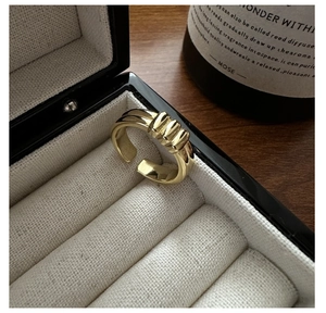 Detail of a minimalist gold wrinkled ridge ring in a premium black jewelry gift box