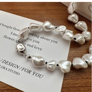 Macro detail of S925 silver clasp and baroque pearls on a knotted aesthetic necklace