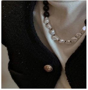 Detail of s925 silver necklace with black onyx beads and irregular baroque pearls on a model