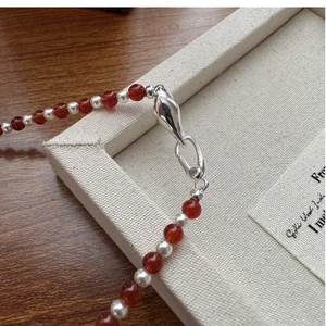 Detailed macro shot of S925 silver necklace with red agate beads and white pearls