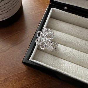 Elegant S925 silver flower ring featuring a sparkling central zircon on a velvet display