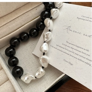 Macro detail of s925 silver necklace with black onyx beads and baroque freshwater pearls