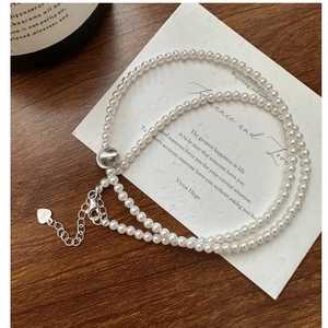 Detail of S925 sterling silver beaded necklace with glossy cat-eye stones and heart charm