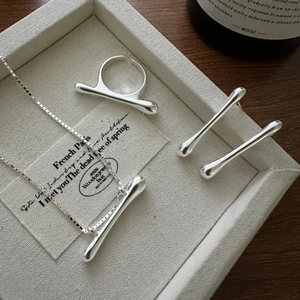 Minimalist silver jewelry set with polished bar pendant necklace, ring, and stud earrings