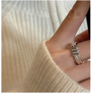 Detail of minimalist S925 sterling silver double-layer ring on knit background
