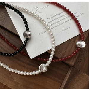 Detail of S925 silver beaded necklaces with cat's eye stone and brushed metal beads