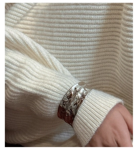 Detail of wide S925 sterling silver cuff bracelet with unique hammered texture on wrist