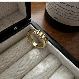 Detailed close-up of a striped gold minimalist open ring set in a premium jewelry box