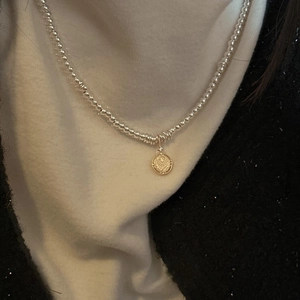 Vintage S925 sterling silver beaded necklace with a golden coin star pendant on a model
