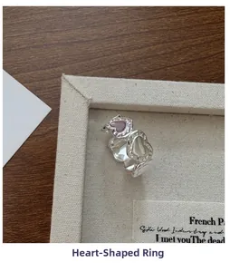 Macro detail of S925 silver heart textured ring with purple and white heart stones
