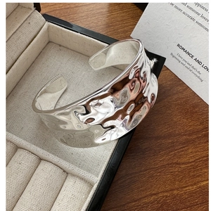 Close-up of S925 silver wide cuff bracelet with irregular hammered water ripple texture