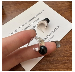 Detail view of S925 silver C-shape earring with black onyx bead and brushed texture