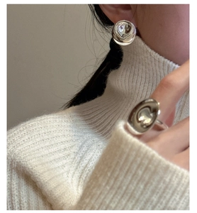 Detail of S925 sterling silver ripple ring with molten texture on white knit