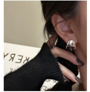 Detail of S925 silver earring with black agate bead worn by model against dark knitwear