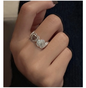Detail of S925 sterling silver ring featuring double heart texture on model hand
