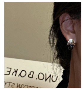Macro view of S925 sterling silver earring with black onyx bead on model ear