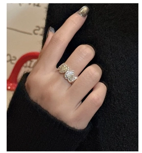 Detailed view of sterling silver rings with heart texture design on female hand
