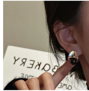 Macro shot of S925 sterling silver earring with black agate bead on model's ear
