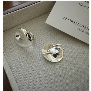 Detailed close-up of two S925 sterling silver rings with irregular polished rippled design
